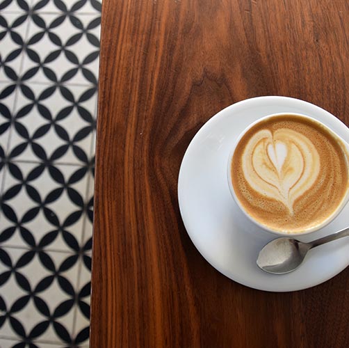 Tasse de café avec du lait formant un coeur sur une table